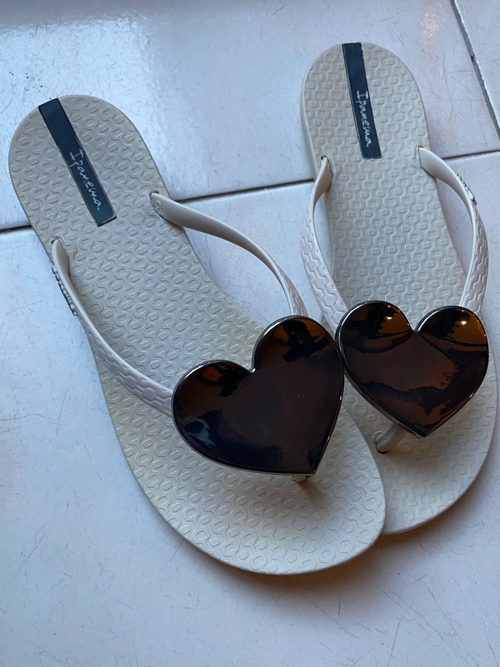 Ipanema Women’s Wave beige Flip Flops with oversized metallic heart accent